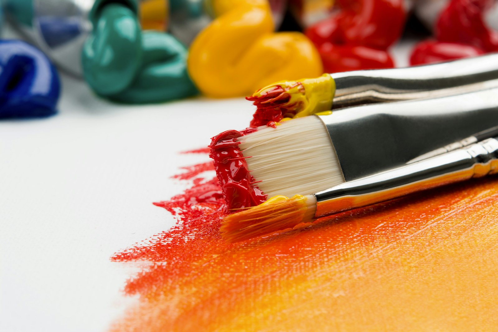 Paint brushes with red and yellow paint on paper